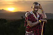  Portrait of a Maasai in traditional clothing at sunset in the landscape, Tanzania, East Africa, Africa 