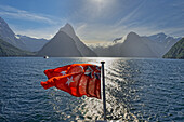 New Zealand flag waving, Milford Sound, South Island, Southland, New Zealand, Australasia 