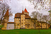 Nidau Castle with Bare Tree and Clouds in an Autumn Day in City of Nidau, Bern Canton, Switzerland.