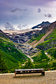 Beautiful Mountain Alp Grüm with Glacier and a Bench in a Cloudy Summer Day in Poschiavo, Bernina, Grisons, Switzerland.