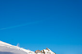 Restaurant and Overhead Cable Car on Ski Slope and Mountain in a Snowy Sunny Winter Day in Kleine Scheidegg, Grindelwald, Canton Bern, Switzerland.