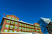 The Famous and Historical Hotel Bellevue des Alpes at 2061 Meters High Up and Mountain Peak of North Face of Eiger 3907 Meter High in a Sunny Winter Day in Kleine Scheidegg, Grindelwald, Canton Bern, Switzerland.