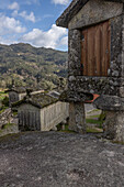  Old stone granaries stand in a mountainous setting, Viana do Castelo, Soajo, Portugal 