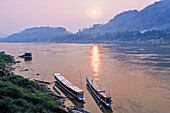 Boote am Fluss bei Sonnenuntergang am Mekong in Luang Prabang, Laos, Südostasien