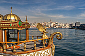 Goldenes orientalisches Restaurantschiff am Ufer von Eminönü, Beyoğlu und der Galataturm, Istanbul, Türkei 