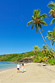 Couple walking on a sandy tropical beach, Drawaqa Island, Yasawa islands, Fiji