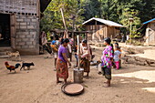  Women crush rice grains in a wooden mortar in Ban Khok Laung village, Chomphet District, Luang Prabang, Laos, Asia 