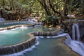 Wasser fließt über Felsen am Wasserfall Kuang Si Falls, in der Nähe von Kuang Si, Bezirk Luang Prabang, Laos, Asien