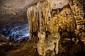  Visitors admire stalactites and stalagmites in Tien Ong Cave, Ha Tu, Halong Bay, Ha Long, Quang Ninh, Vietnam, Asia 