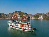  Aerial view of the boutique cruise ship Ylang (Heritage Line) in front of karst islands, Lan Ha Bay, Haiphong, Vietnam, Asia 