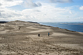 Wanderer und Gleitschirmflieger auf der Sanddüne 'Grande Dune du Pilat' am Bassin d’Arcachon, Arcachon, Gironde, Nouvelle-Aquitaine, Frankreich