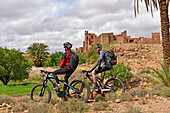 Riders on mountain bike with electric assistance in front of the Ksar of Tamedakhte, Ounila River valley, Ouarzazate Province, region of Draa-Tafilalet, Morocco, North West Africa