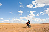 Rider on mountain bike with electric assistance on a track between Ouarzazate and Ait Ben Haddou, Ounila River valley, Ouarzazate Province, region of Draa-Tafilalet, Morocco, North West Africa