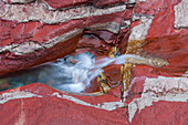 Bach fliesst durch eisenhaltiges Gestein, Red Rock Canyon, Waterton Lakes Nationalpark, Alberta, Kanada