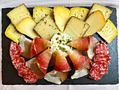 Steinteller mit typischer Brotzeitplatte wie Käse, Salami und Schinken, Kanton Solothurn, Schweiz.