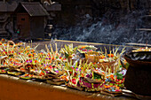 An altar table with traditional Balinese offerings and smoking incense sticks at Tirta Empul Temple (Pura Tirta Empul). Tampaksiring, Bali, Indonesia.