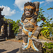 Intricately carved stone statue of a guardian at Batu Mejan Temple (Pura Batu Mejan). Tanah Lot, Bali, Indonesia.
