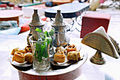 Pfefferminztee arabischer Art mit vier Stücken Hlou, tunesischer Patisserie, serviert auf Silbertablett mit Silberkanne in tunesischem Café in Hammamet , Tunesien