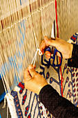  Woman weaving carpets in a carpet shop in the Medina of Hammamet, Tunisia 