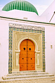  Ornamental portal with colored tiles, arabesques, and entrance door with nail decorations to the Great Mosque (Grande mosquée de Nabeul) in the Medina of Nabeul, Tunisia 