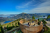 Zwei Personen sitzen auf Aussichtsplattform, im Hintergrund Wolfgangsee und Schafberg, Zwölferhorn, Salzkammergut, Salzburg, Österreich