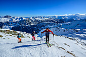  Three people on ski tour ascending to the Schneegrubenspitze, Schneegrubenspitze, Kurzer Grund, Kitzbühel Alps, Tyrol, Austria 