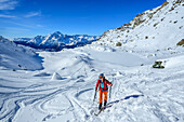  Woman on ski tour ascending to Passo di Campagneda, Alpe Prabello, Bernina Range, Lombardy, Italy 