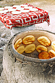  Traditional production of Berber bread (Tabouna, Khobz Tabouna) in an open, wood-fired clay oven (clay pot) in El Metbassta in the Kairouan Governorate, Tunisia 