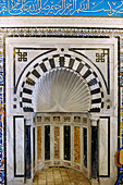 Mit Muschelmotiv und farbigem Marmor geschmückter Mihrab der Koranschule Medersa Slimania in der Medina in Tunis, Tunesien