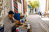  Arched alley with artisans working on brass plates next to the portal to the Hammam el-Kachachine in the Medina of Tunis, Tunisia 