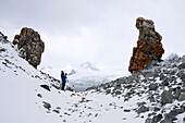 Wanderer fotografiert Felsformationen im Schnee, auf Half Moon Island, Südshetlandinsel, Südliche Shetlandinseln, Südamerika, Antarktis