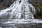 Wanderer auf Felsen vor Wasserfall, Dynjandi, Insel Island, Nordeuropa, Europa