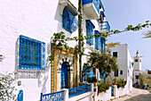 Gasse mit blauer Holztüre und Fenstergittern in der (Medina) Altstadt von Sidi Bou Said, Tunesien
