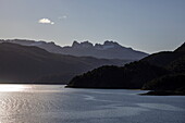  Sunlight reflects in the Murray Channel with mountains in fifty shades of grey, near Ushuaia, Tierra del Fuego, Patagonia, Argentina, South America 