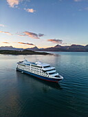  Aerial view of the expedition cruise ship Ventus Australis (Australis Cruises) in the Beagle Channel with silhouetted islands and mountains at sunset, near Ushuaia, Tierra del Fuego, Patagonia, Argentina, South America 