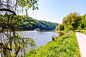  Hiking trail along the Danube from Kelheim via the Danube Gorge to Weltenburg Monastery with a view of a pleasure boat, Bavaria, Germany 