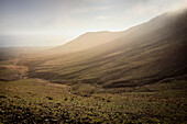  Warm backlight envelops the mountains at the Mirador de Cofete (viewpoint Cofete beach), Fuerteventura, Canary Islands, Spain, Europe 