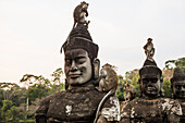 Affen sitzen auf Göttern und Dämonen an der südlichen Zufahrtsstraße zum Angkor Thom Tempel, Angkor, Siem Reap, Kambodscha, Südostasien