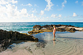 Girl waiting for wave at Blowhole beach at Pointe des Chateaux, Grande-Terre, Guadeloupe, overseas region of France,Leewards Islands, Lesser Antilles, Caribbean
