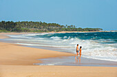 Woman and man walking on Tangalle beach,Sri Lanka, Indian subcontinent, South Asia