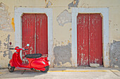 Roter Vespa-Roller geparkt vor einem alten Gebäude, Gialos, Insel Symi, Dodekanes, Griechenland 