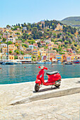  Roter Vespa-Roller geparkt im Hafen von Gialos, Gialos, Insel Symi, Dodekanes, Griechenland 