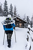 Schneeschuhgeherin an der Schärtenalm über dem Hintersee im Winter, Ramsau, Berchtesgadener Alpen, Oberbayern, Bayern, Deutschland
