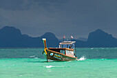  Longtail boat speeding towards the beach, with a thunderstorm approaching behind, Koh Ngai Island, Andaman Sea, Satun Province, Southern Thailand, Thailand, Asia 