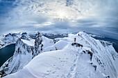  Several people climb the summit ridge of Husfjell, Husfjell, Senja, Troms, Norway 