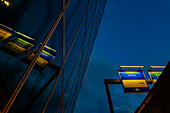 Modern Glass Building with Reflection and Illuminated Road Sign to Zurich Airport at Night in the Airport in Kloten, Zurich, Zurich Canton, Switzerland.