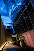 Illuminated Road with a Wall and Modern Glass Building with Reflection to Circle in Dusk in Kloten in Zurich Airport in Kloten, Zurich, Zurich Canton, Switzerland.