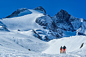  Two people on ski tour ascending towards Gabler, Gabler and Reichenspitze in the background, Zillertal Alps, Salzburg, Austria 
