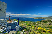Zwei Frauen beim Wandern stehen vor einer Kapelle mit Blick auf Bucht von Kalamitsa, Kochylas Peak, Skyros, Ägäis, Sporaden, Mittelgriechenland, Griechenland