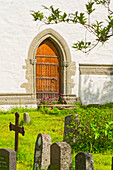  Side door and cemetery of one of the northernmost stone churches in the world, the famous church at Vagsfjord, Harstad, Troms, Norway 